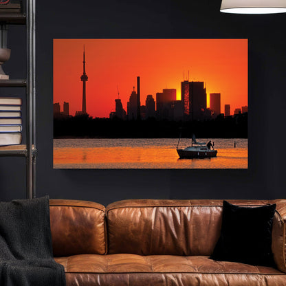 Toronto skyline at sunset with sailboat on water at Ashbridges Bay