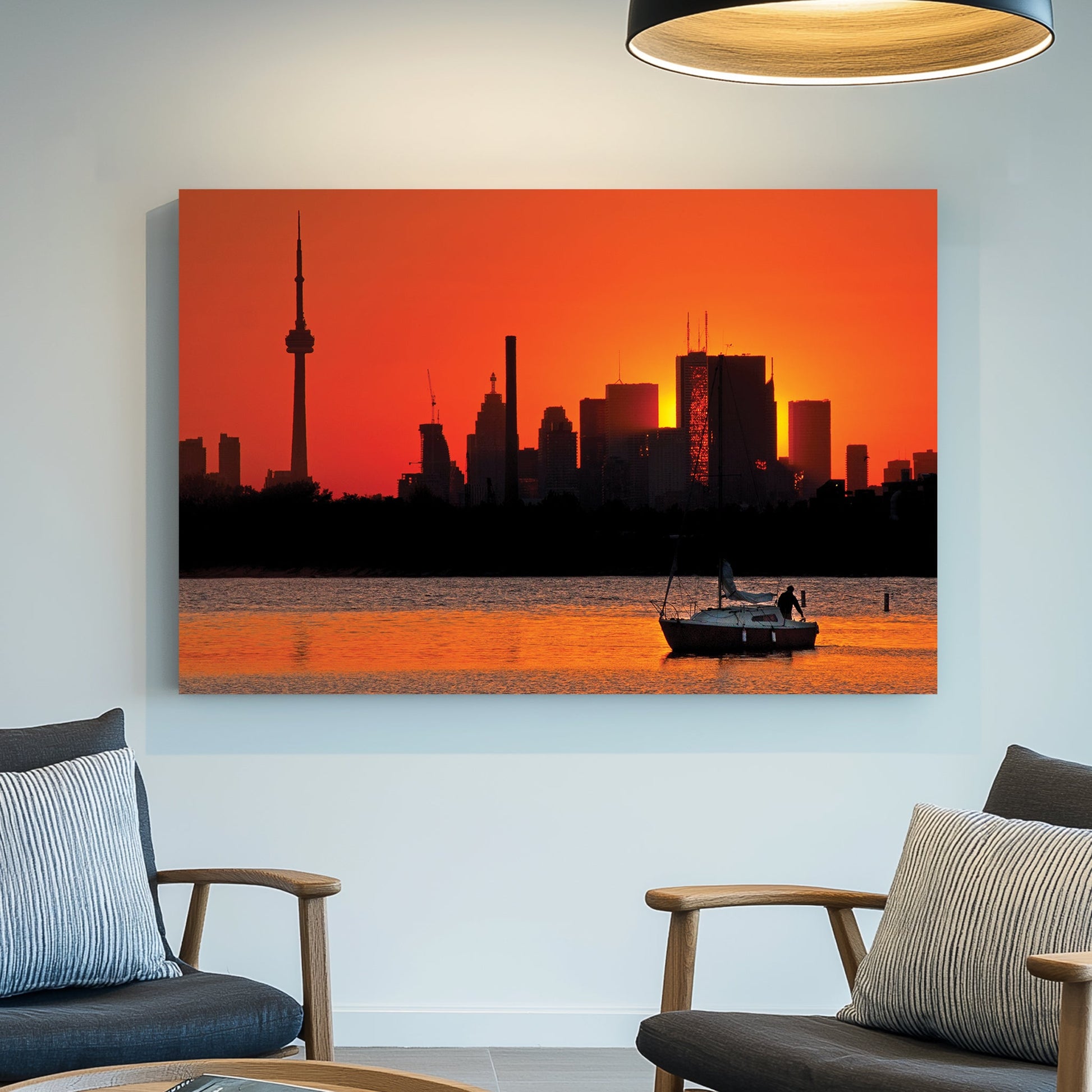 Toronto skyline at sunset with sailboat on water at Ashbridges Bay