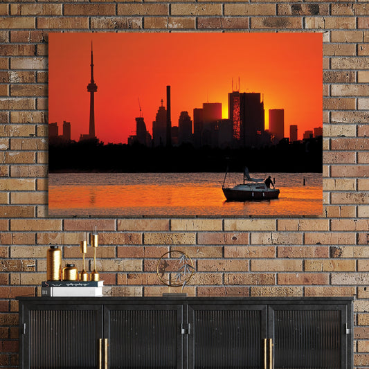 Toronto skyline at sunset with sailboat on water at Ashbridges Bay