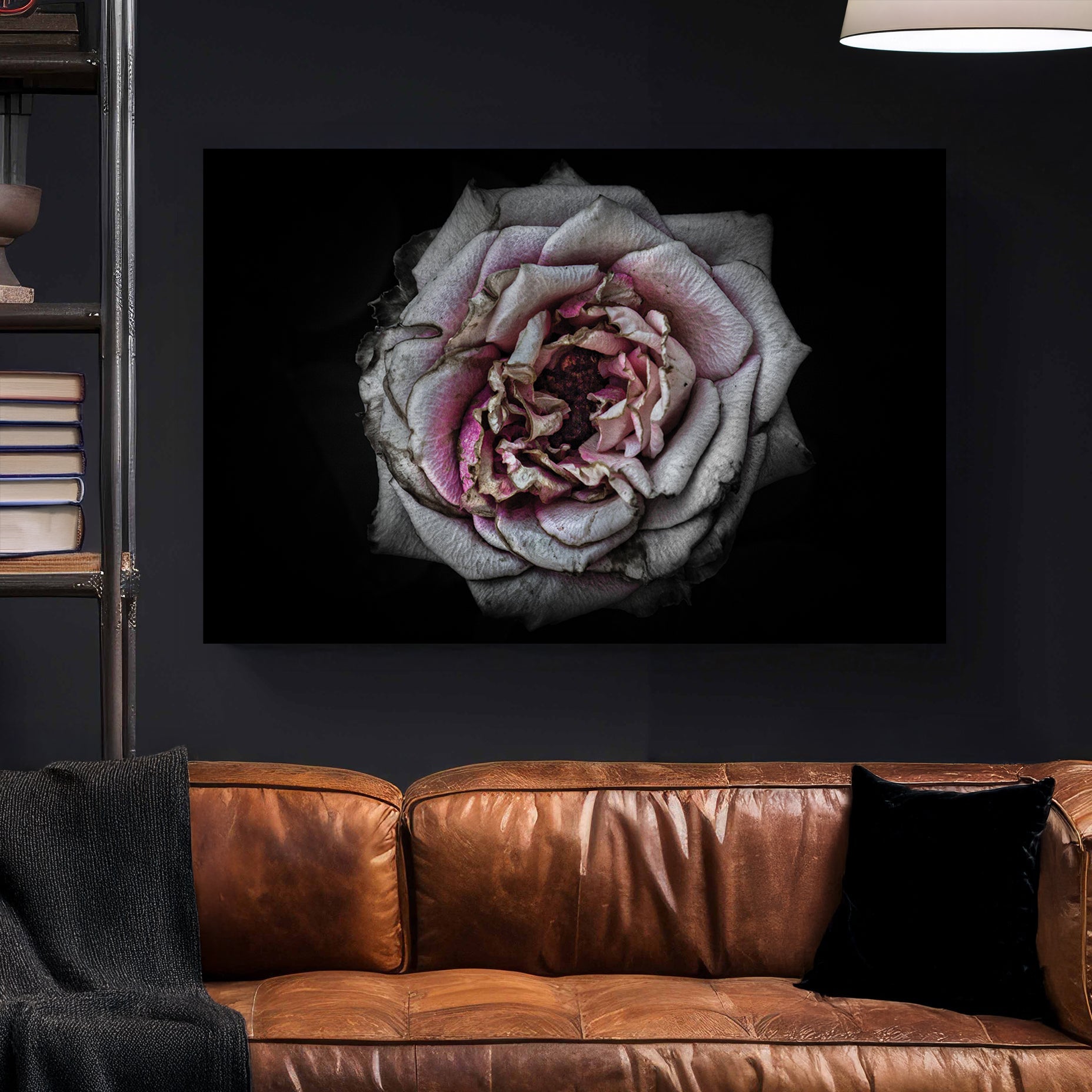 Faded close-up of a dusty pink rose with aged petals on a black background