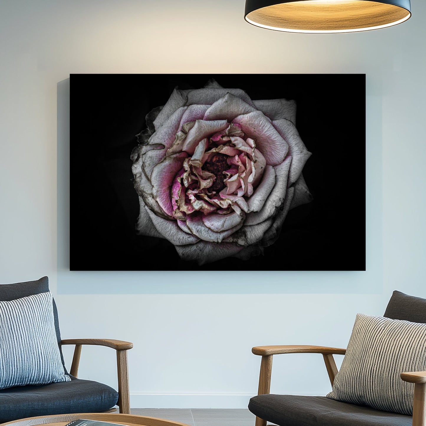 Faded close-up of a dusty pink rose with aged petals on a black background