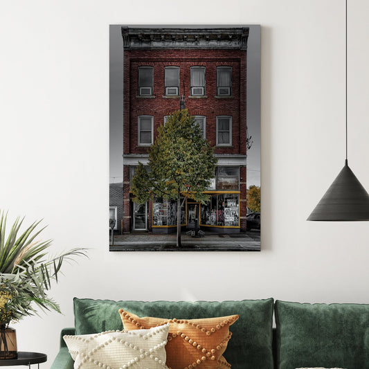 Vintage red-brick storefront with urban posters and single tree, moody sky backdrop