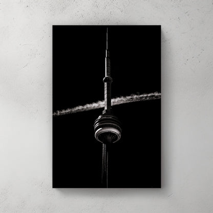 Black and white CN Tower photo with jet trail crossing sky
