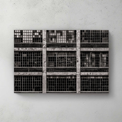 black and white industrial building with broken window panes and symmetrical grid layout