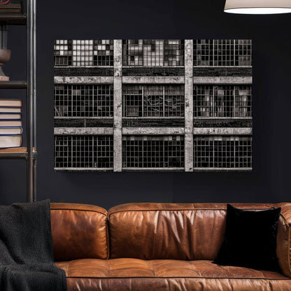 black and white industrial building with broken window panes and symmetrical grid layout