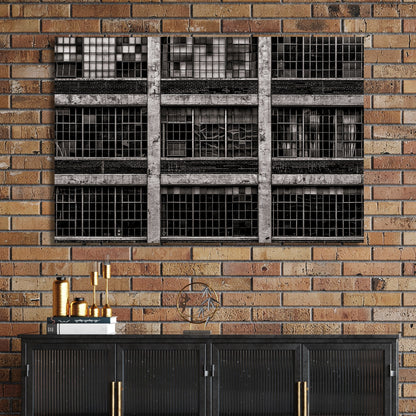 black and white industrial building with broken window panes and symmetrical grid layout