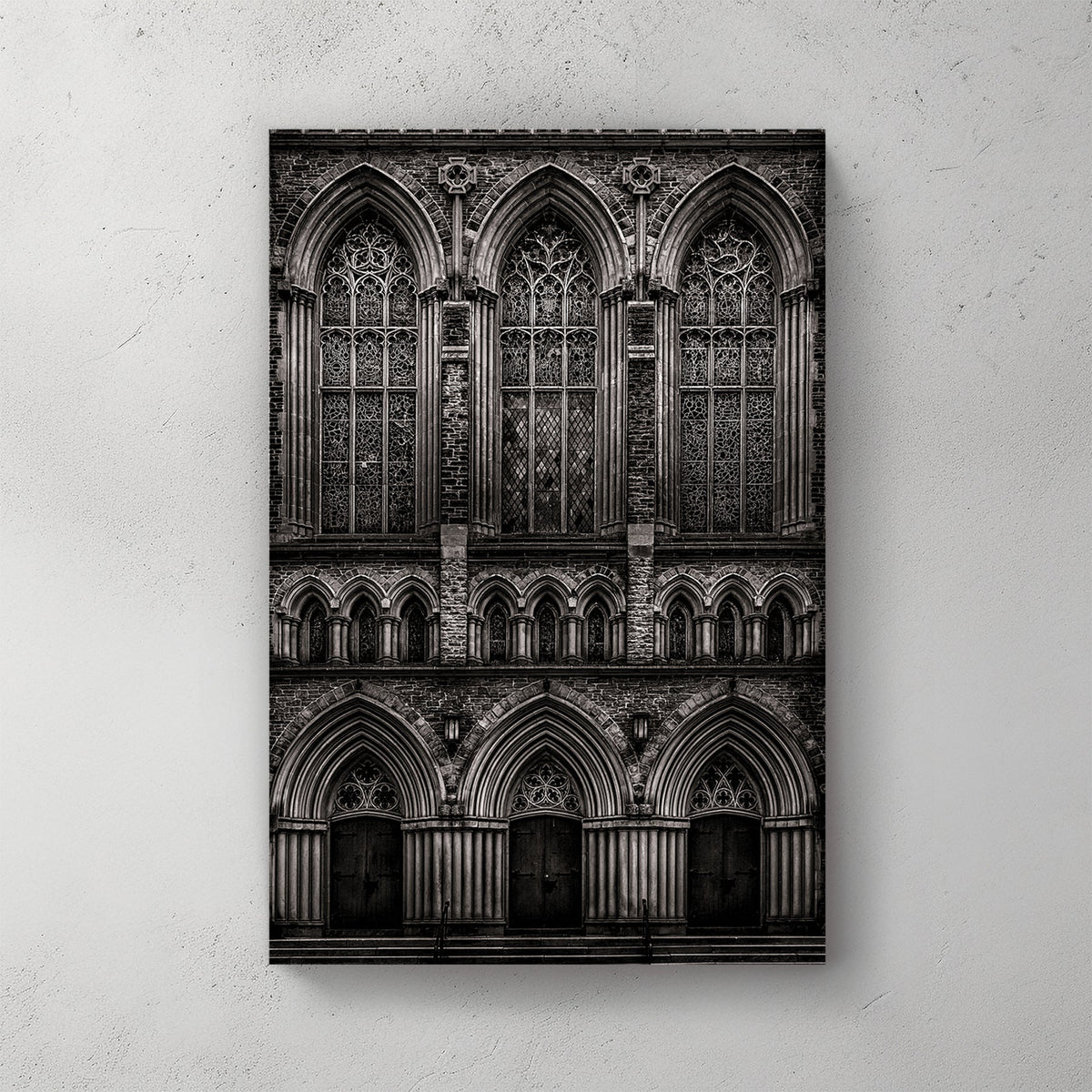 black and white photo of gothic church façade with stained glass windows and arched doors