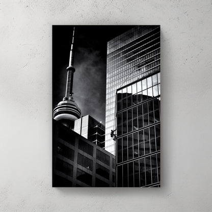 black and white photo of CN Tower and window washer on Toronto skyscraper