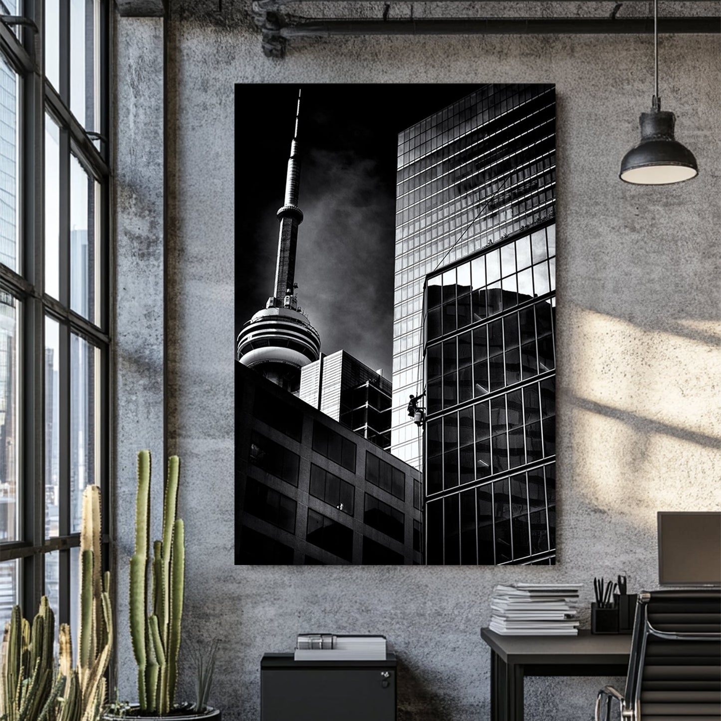 black and white photo of CN Tower and window washer on Toronto skyscraper