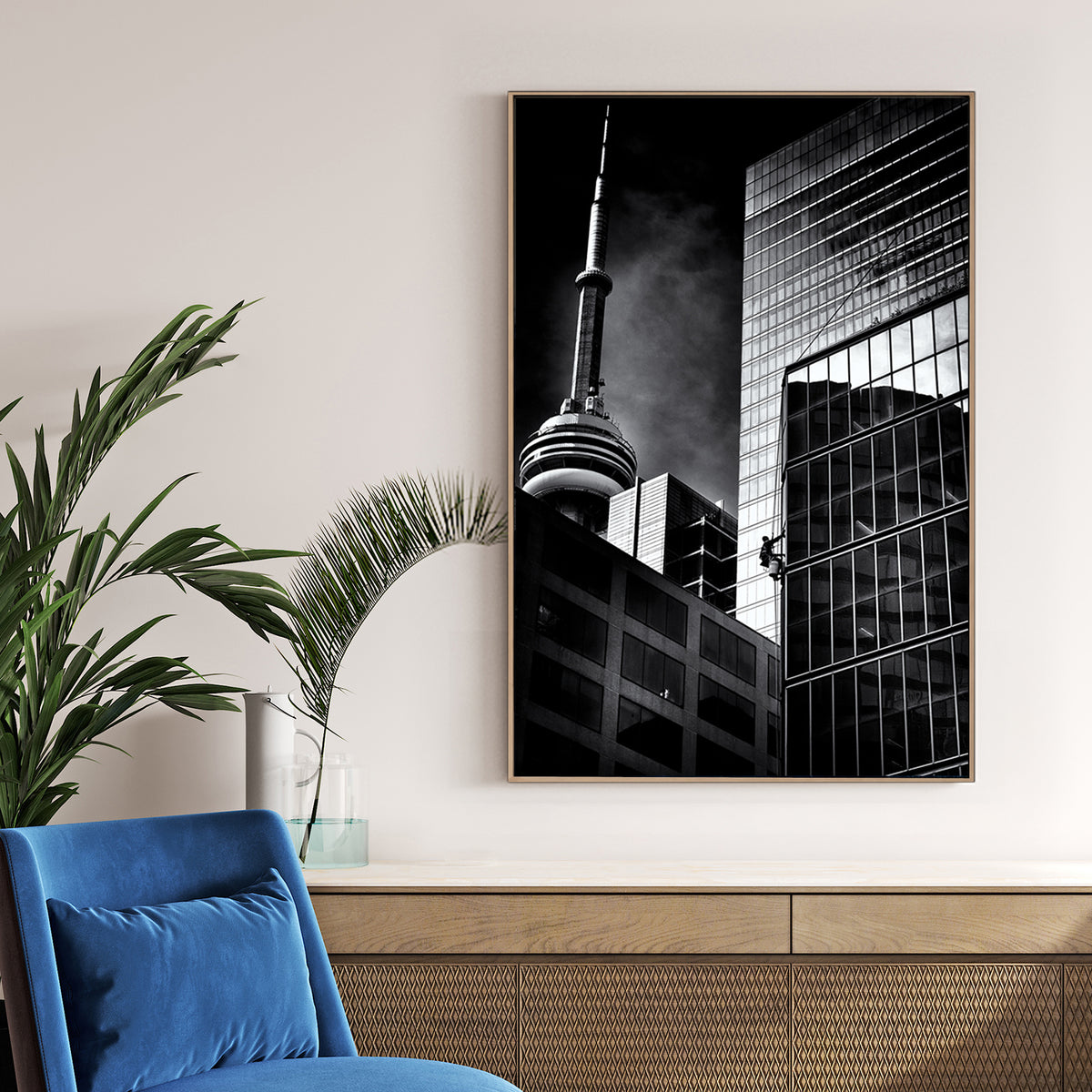 black and white photo of CN Tower and window washer on Toronto skyscraper
