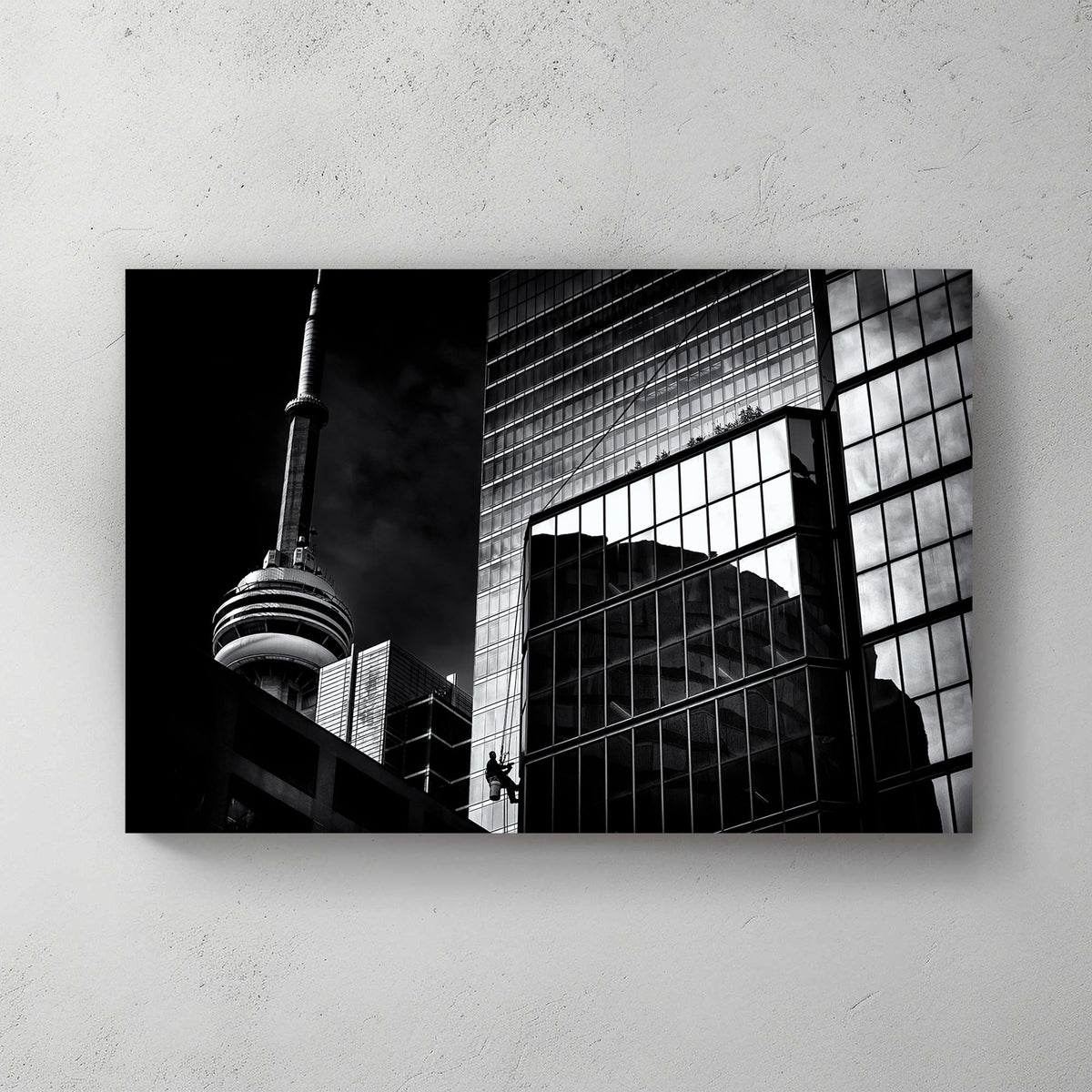 black and white Toronto photo with CN Tower and window washer on glass building