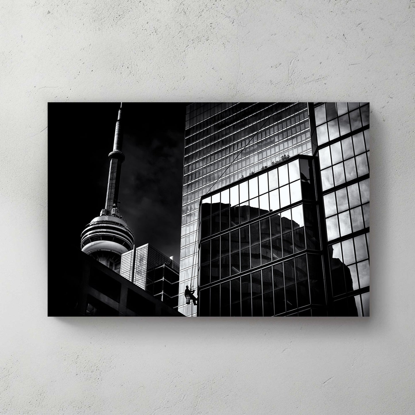 black and white Toronto photo with CN Tower and window washer on glass building