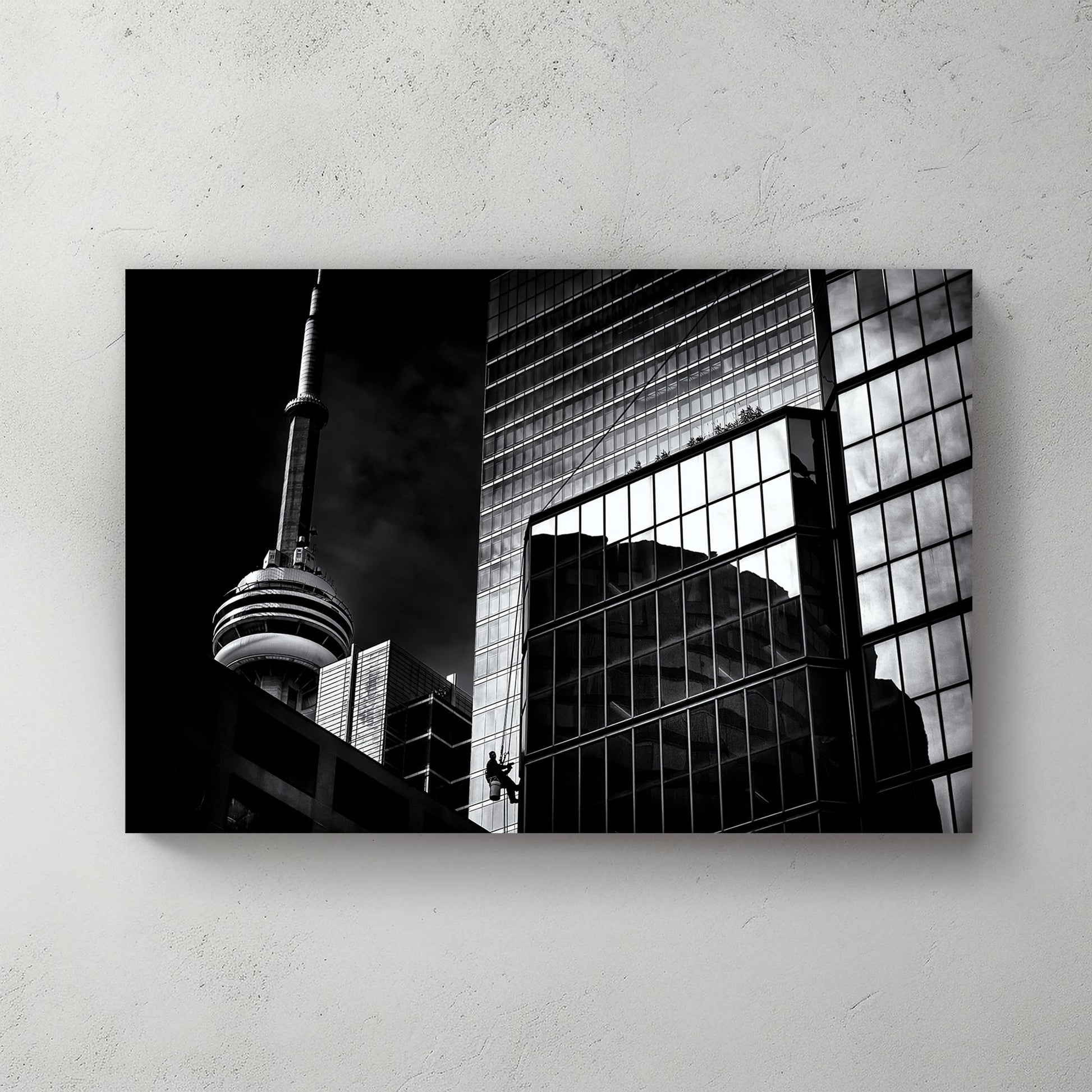 black and white Toronto photo with CN Tower and window washer on glass building