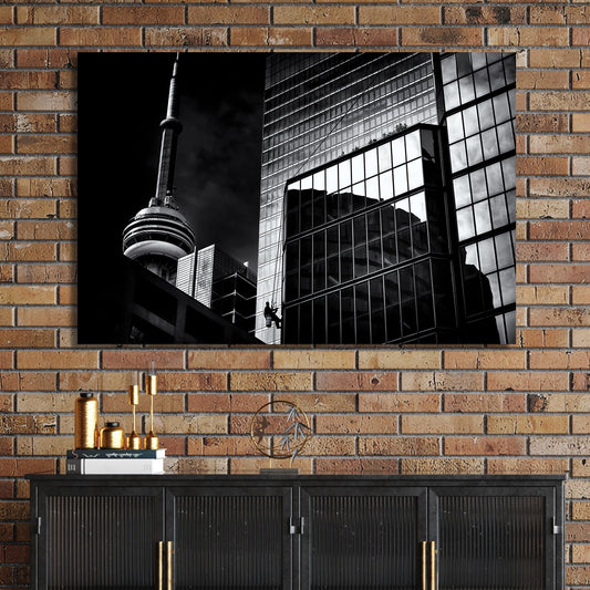 black and white Toronto photo with CN Tower and window washer on glass building