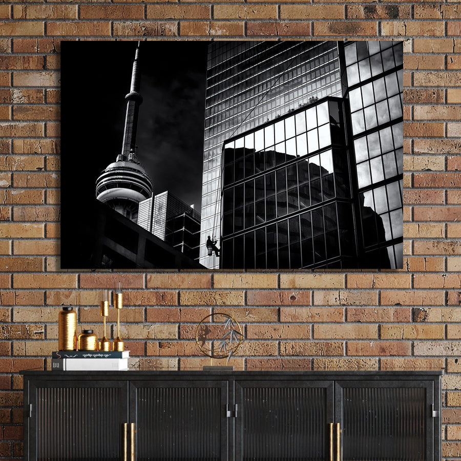black and white Toronto photo with CN Tower and window washer on glass building