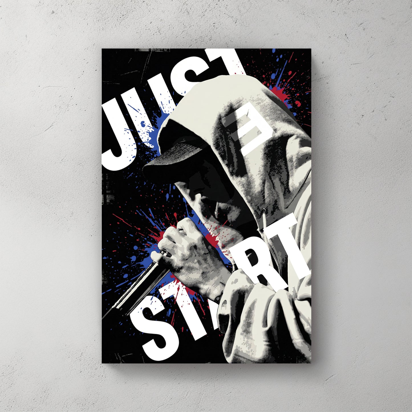 Eminem in dark hoodie holding mic, red and blue splatter paint, JUST START text wrapping around frame — canvas wall art print