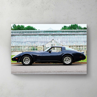Deep navy C3 Corvette in profile in front of a vintage glass greenhouse, raised-white-letter tires — canvas wall art print