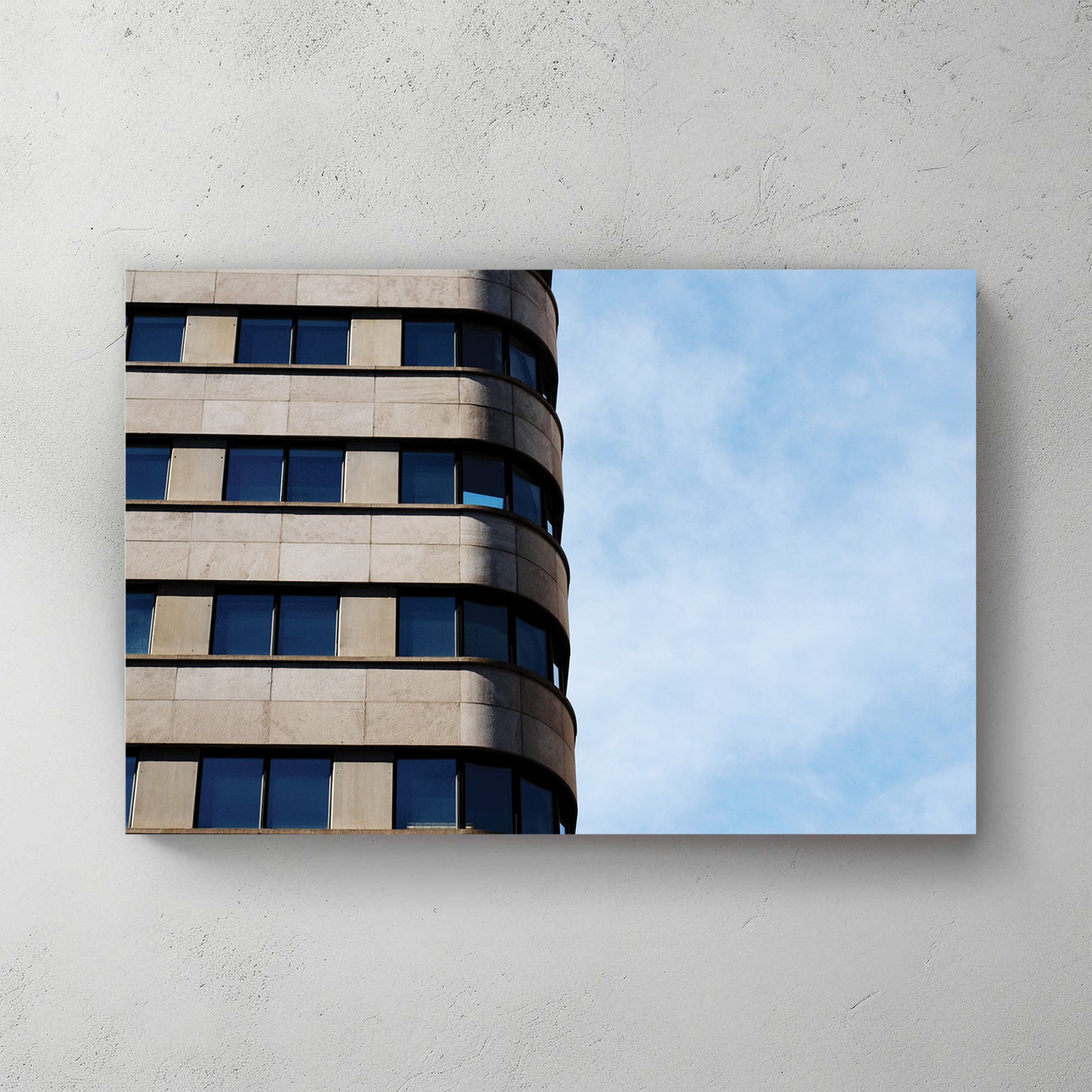 Curved modernist office tower, ribbon of windows wrapping the corner against a bright blue sky — canvas wall art print