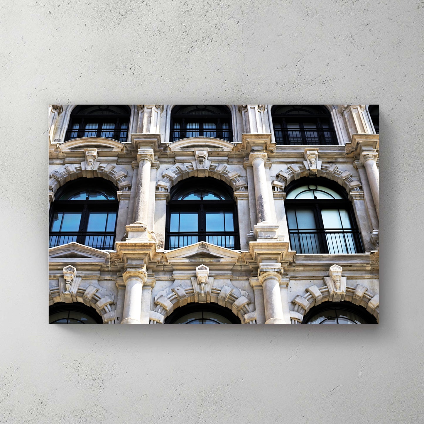 Ornate Beaux-Arts stone facade, arched windows, columns and carved detail in warm daylight — canvas wall art print