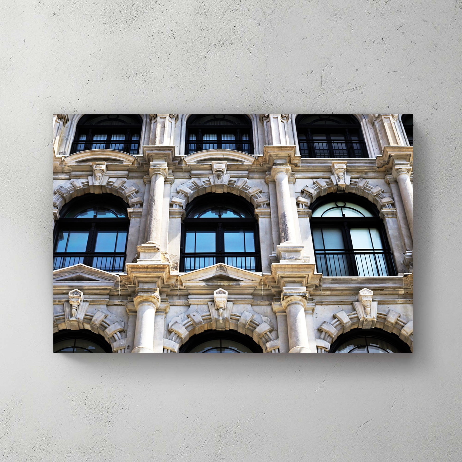Ornate Beaux-Arts stone facade, arched windows, columns and carved detail in warm daylight — canvas wall art print