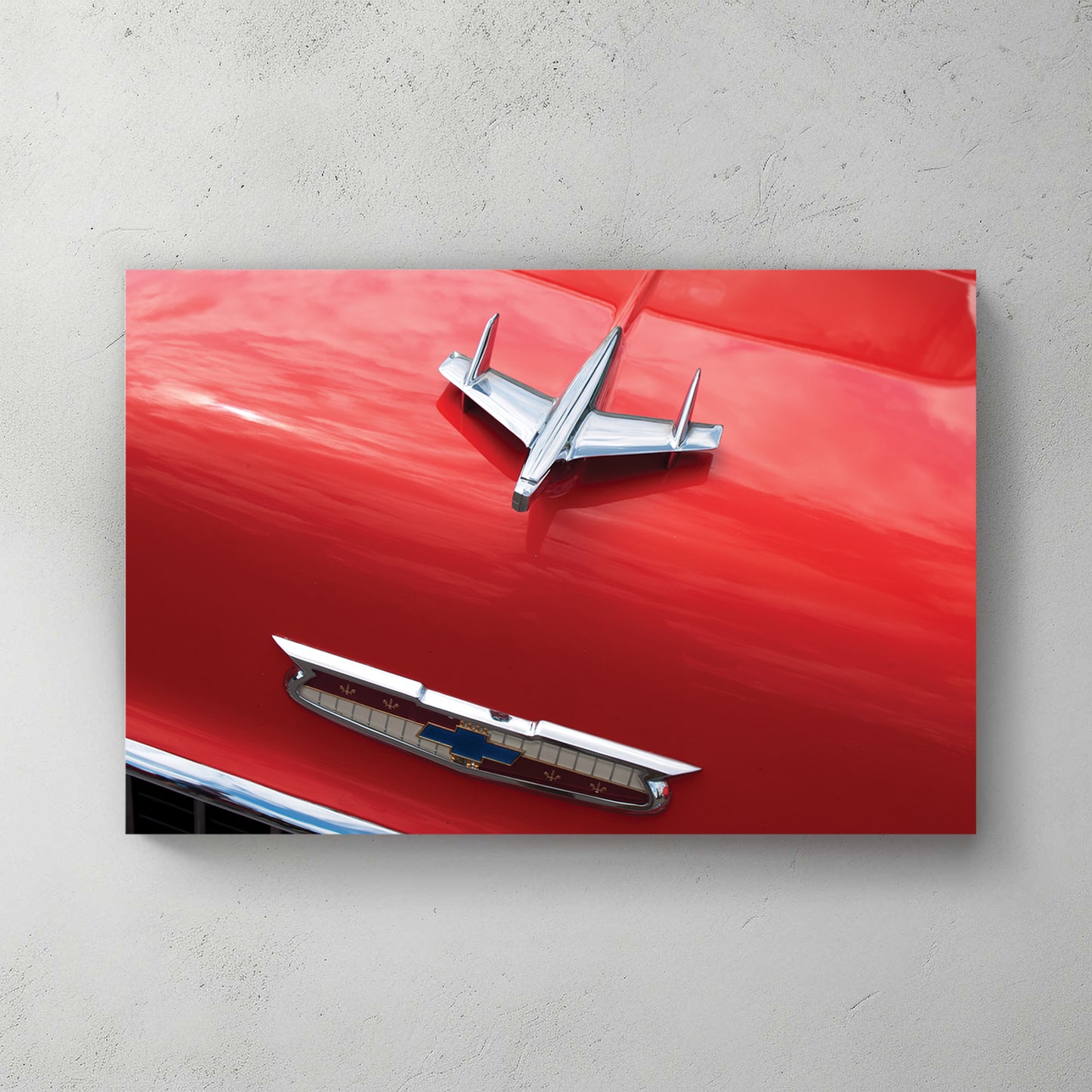Chrome jet-bird hood ornament and gold Chevy V emblem on a glossy red '55 Bel Air hood — canvas wall art print