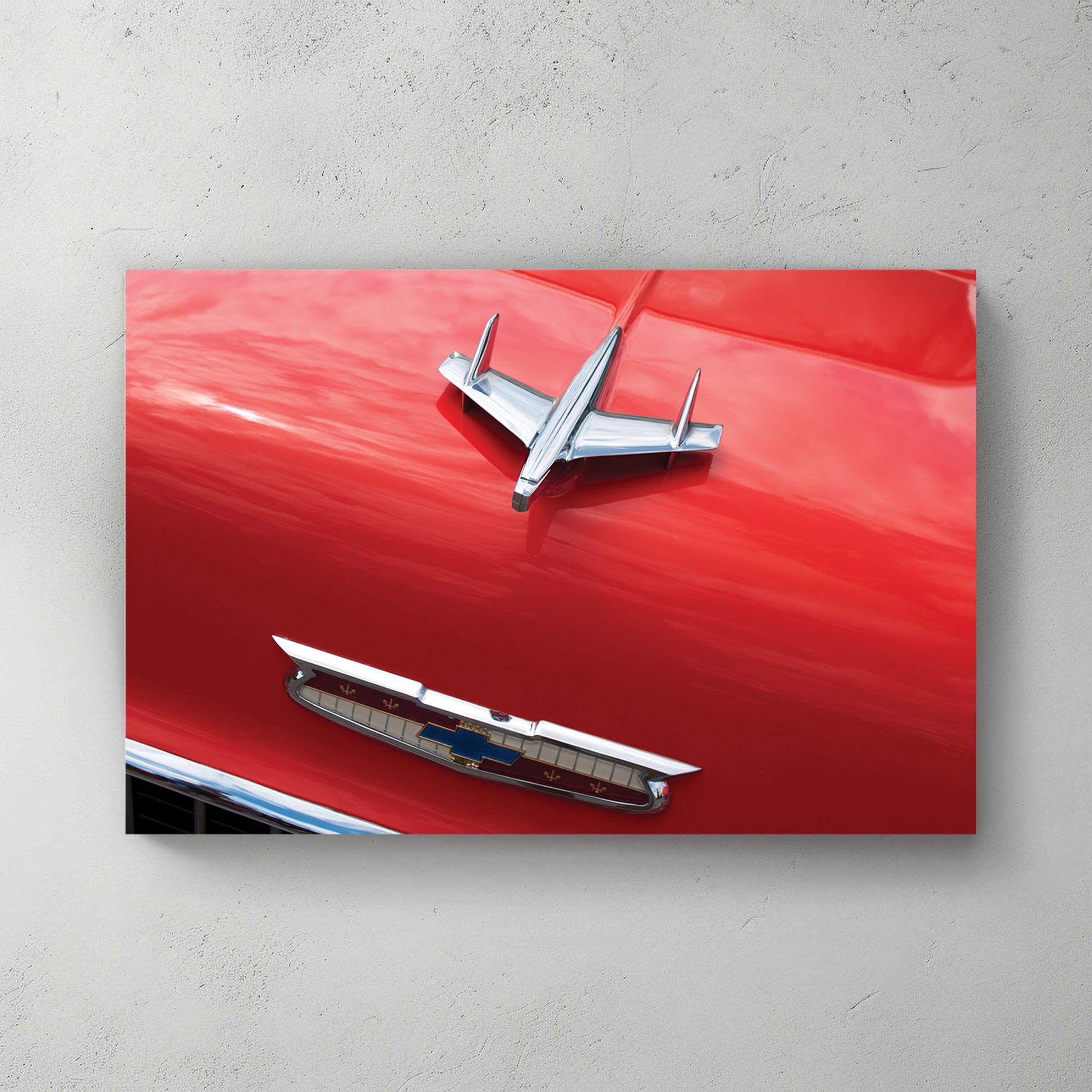Chrome jet-bird hood ornament and gold Chevy V emblem on a glossy red '55 Bel Air hood — canvas wall art print