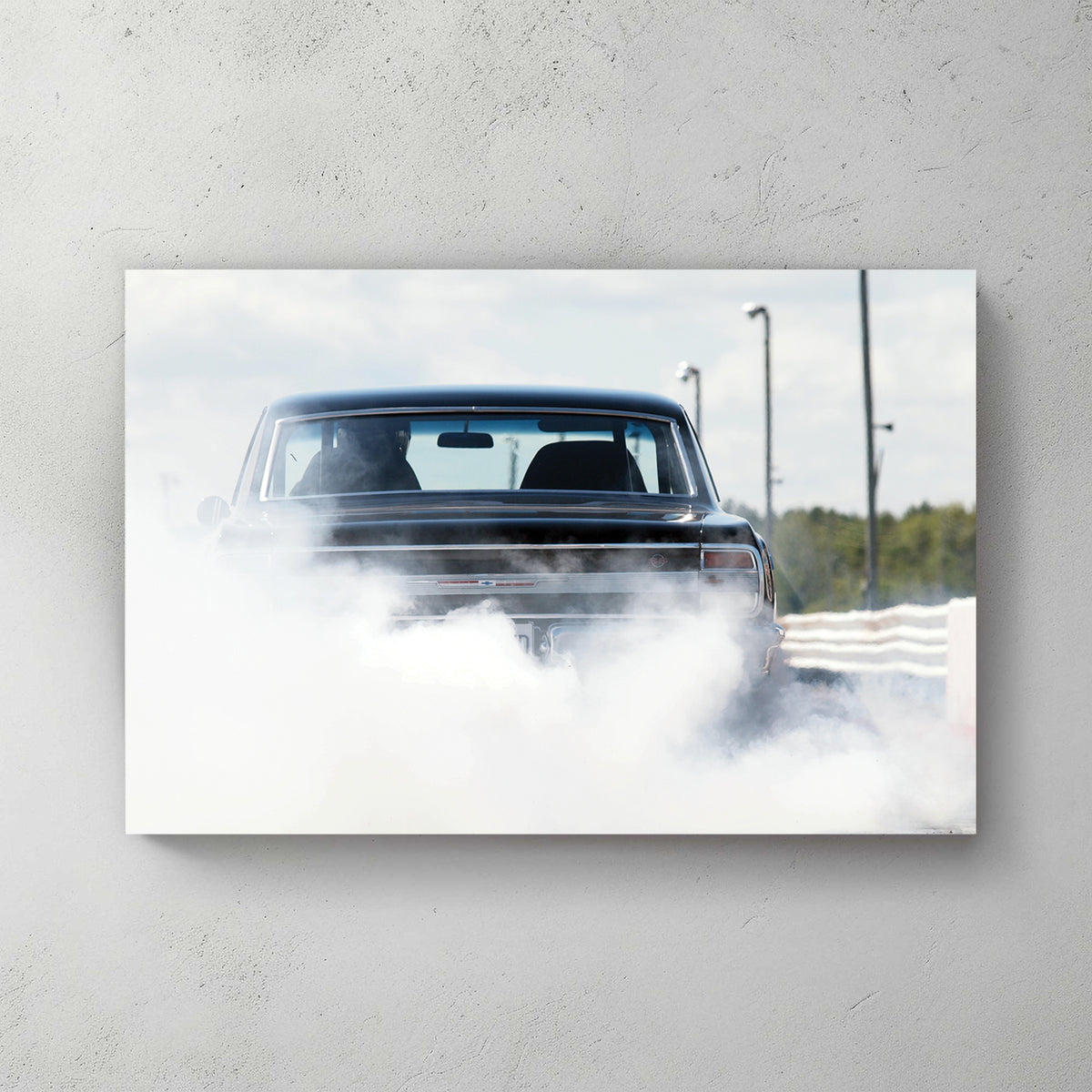 Black muscle car doing a burnout, rear wrapped in a cloud of white tire smoke on a sunny strip — canvas wall art print
