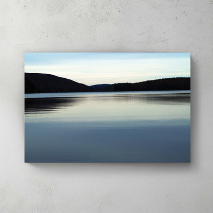 Calm blue lake at dusk, rolling forested hills on the horizon under a soft pastel sky — canvas wall art print
