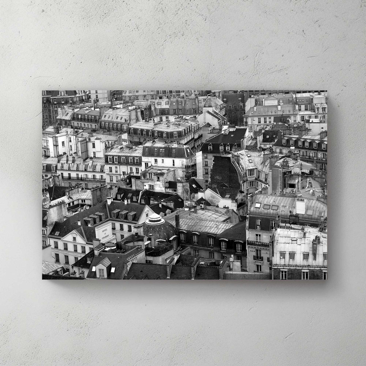 Aerial black-and-white sweep of Paris rooftops, chimneys, domes and mansard roofs packed to the horizon — canvas wall art print