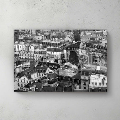 Aerial black-and-white sweep of Paris rooftops, chimneys, domes and mansard roofs packed to the horizon — canvas wall art print