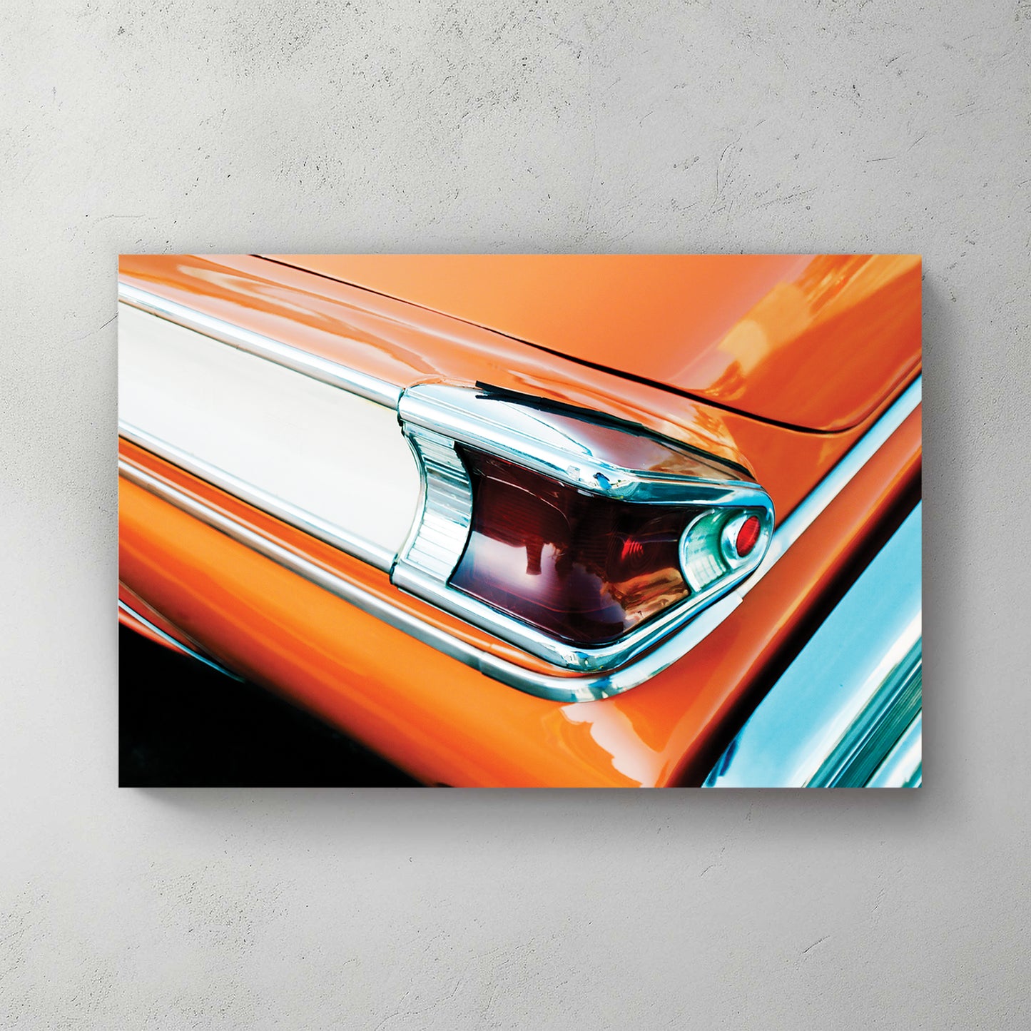 Close-up of a glossy orange classic car's chrome-trimmed tailfin and jewelled taillight — canvas wall art print