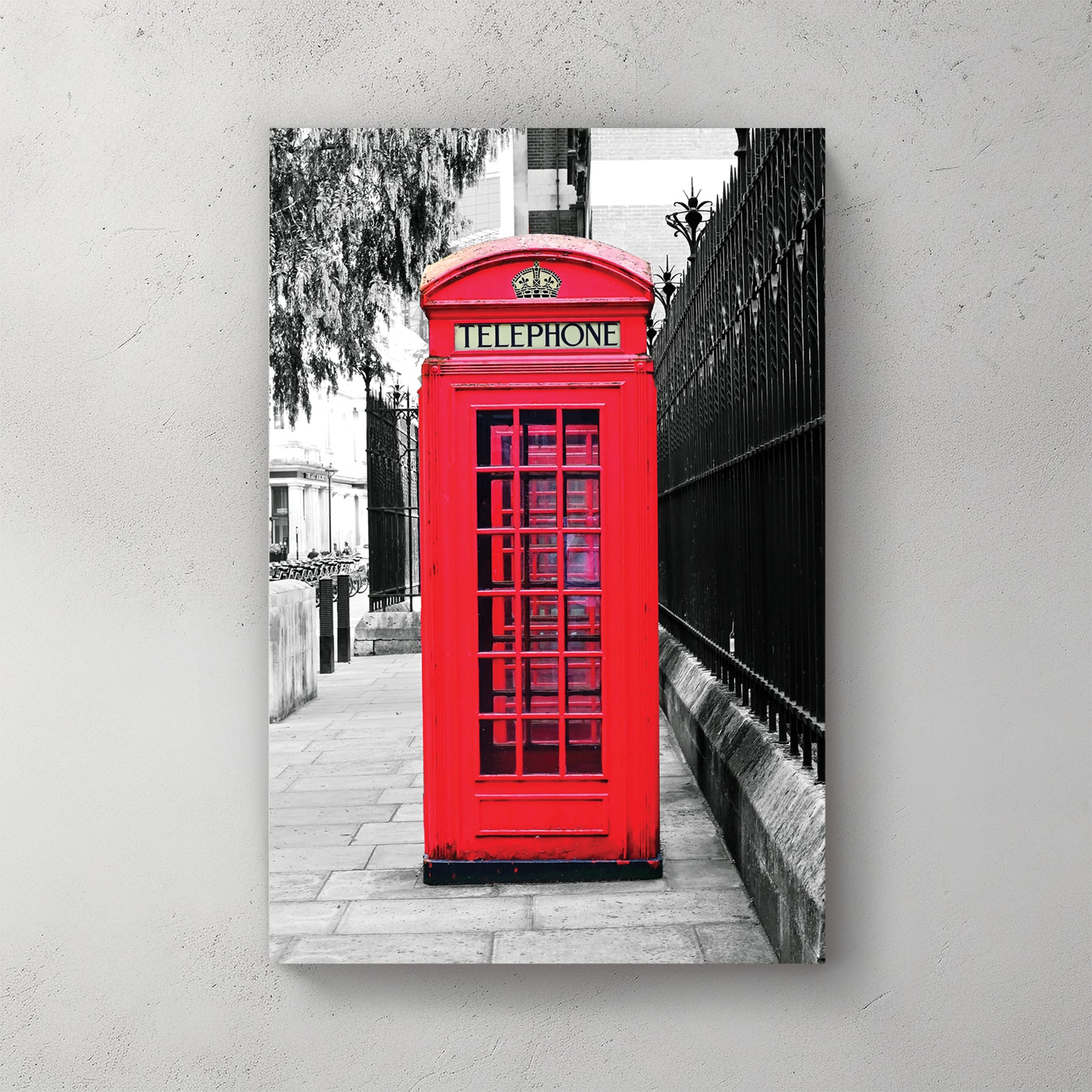 Iconic red London phone box in sharp spot-colour against a black-and-white street and iron railing — canvas wall art print