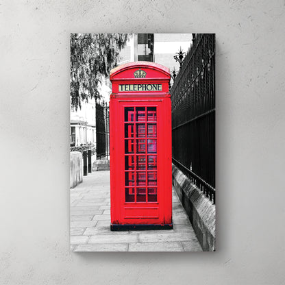 Iconic red London phone box in sharp spot-colour against a black-and-white street and iron railing — canvas wall art print