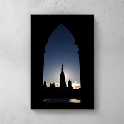 Ottawa's Parliament spire framed in a Gothic stone arch, backlit by a pale winter sun — canvas wall art print