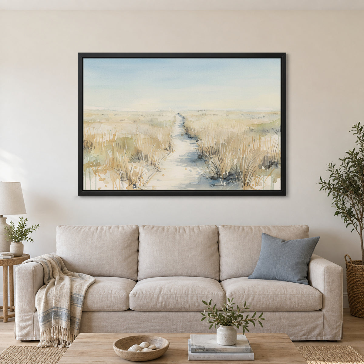 Sandy Dune Path Coastal framed canvas in a black floating frame above a linen sofa with a blue cushion