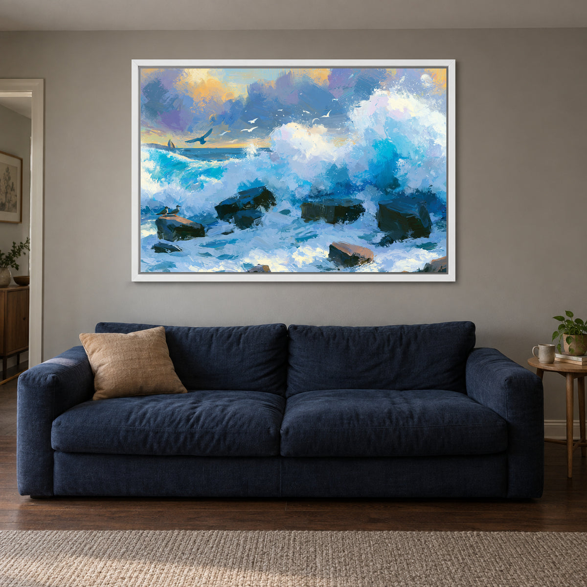 Crashing Ocean Waves Gold Sunset framed canvas in a white floating frame above a navy sofa