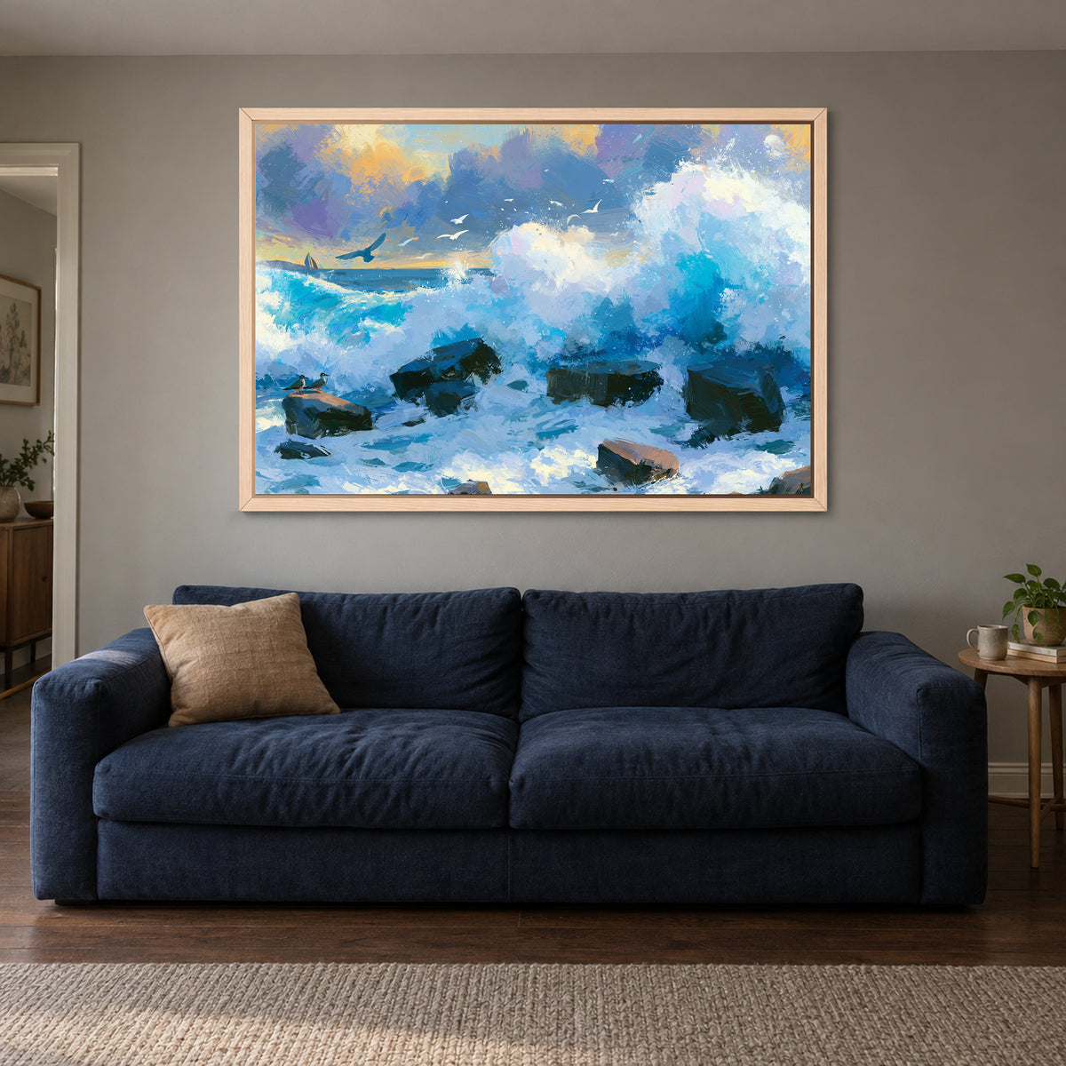 Crashing Ocean Waves Gold Sunset framed canvas in a natural wood floating frame above a navy sofa