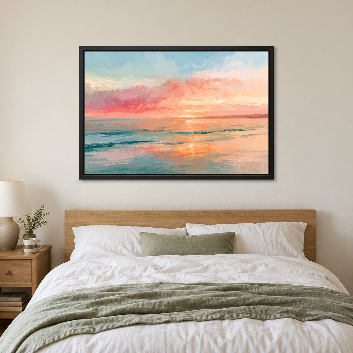 Calm Ocean Pink Sunset framed canvas in a black floating frame above a bed with white linens and a sage throw