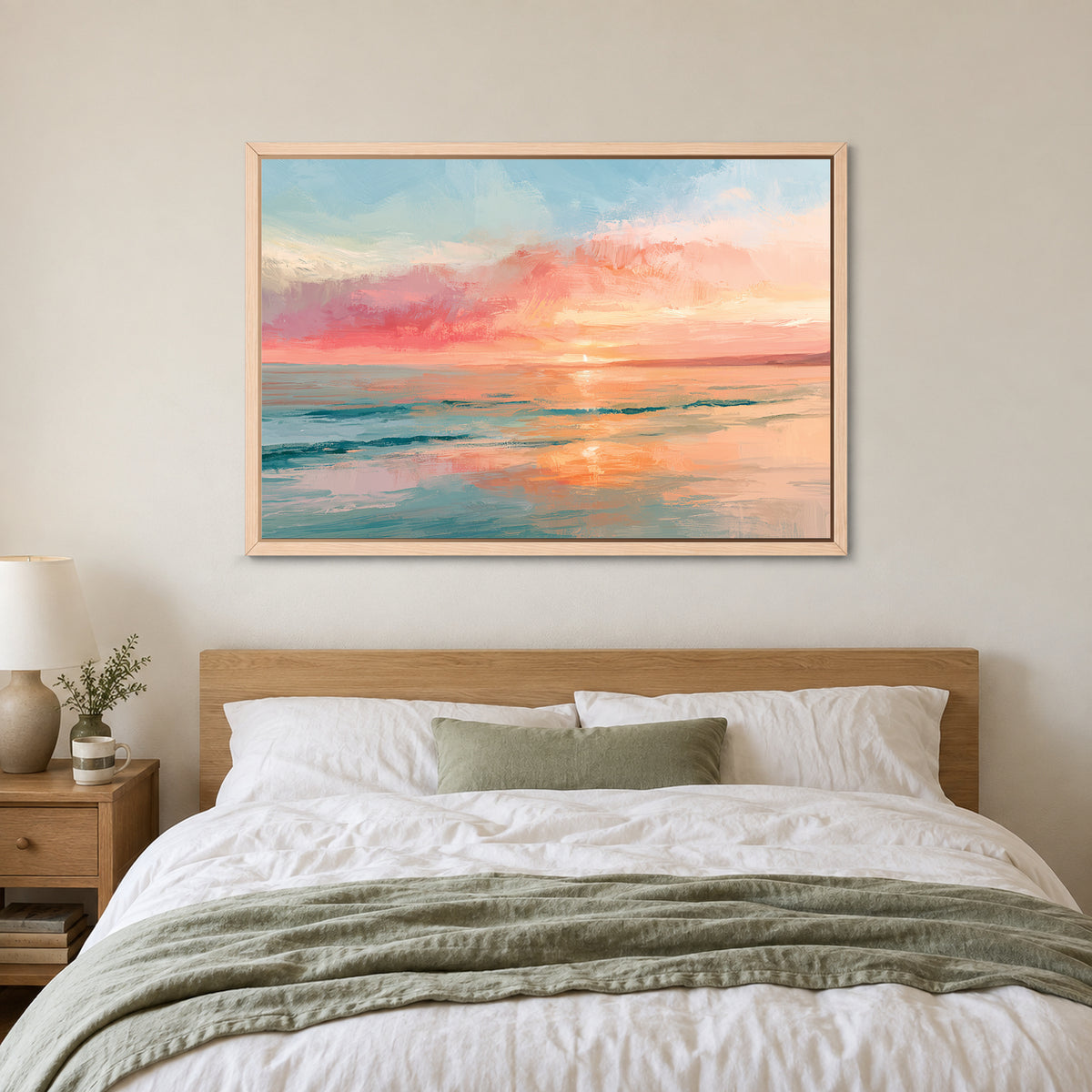 Calm Ocean Pink Sunset framed canvas in a natural wood floating frame above a bed with white linens and a sage throw