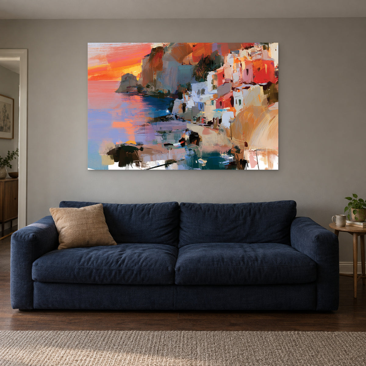 Coastal Town Sunset Headland canvas wall art above a navy sofa in a living room