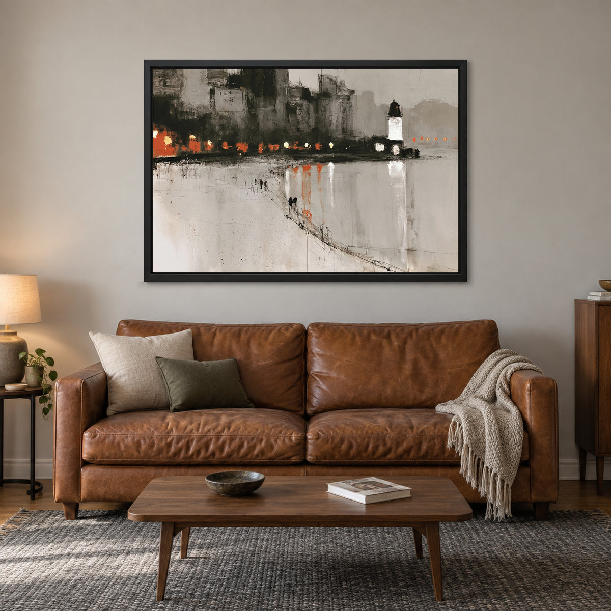Harbour Lighthouse Night Lights framed canvas in a black floating frame above a cognac leather sofa with a wooden coffee table