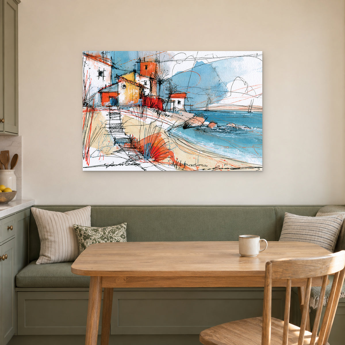 Coastal Cottages Ink Sketch canvas wall art above a green banquette and wooden table in a breakfast nook