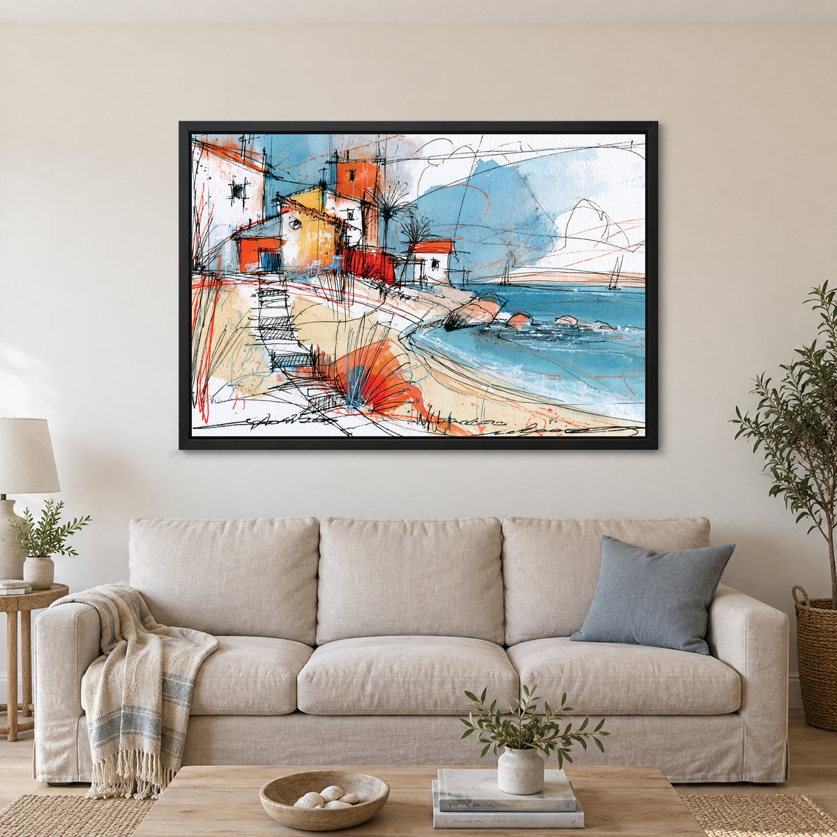 Coastal Cottages Ink Sketch framed canvas in a black floating frame above a linen sofa with a blue cushion