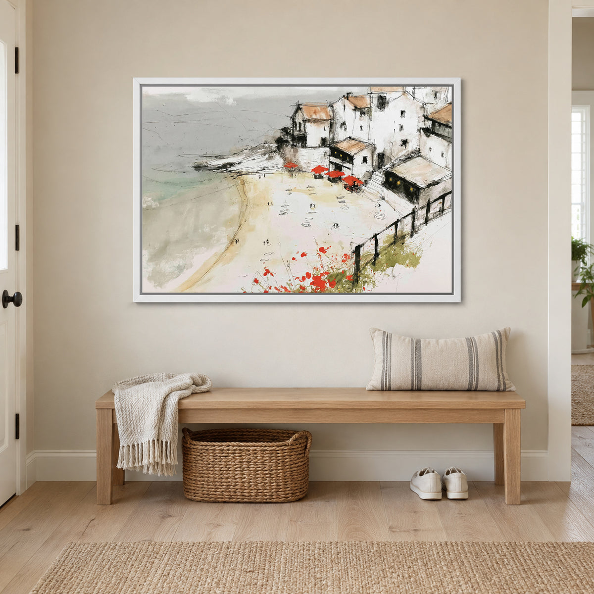 Clifftop Town Red Parasols framed canvas in a white floating frame above a wooden entryway bench with a woven basket