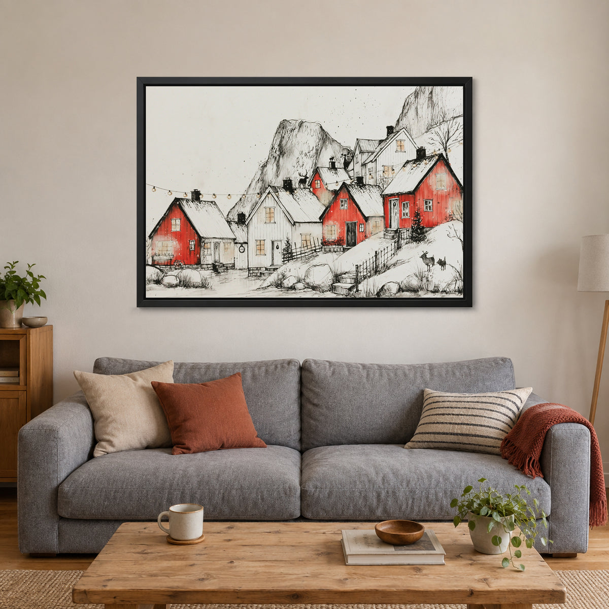 Norwegian Red Cabins Snow framed canvas in a black floating frame above a grey sofa with rust and striped cushions
