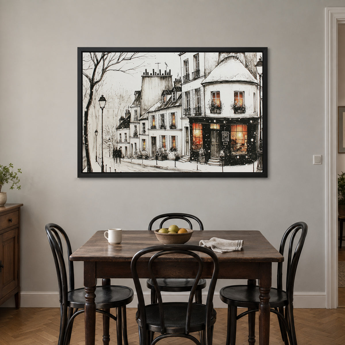 Paris Corner Shop Snow framed canvas in a black floating frame above a small wooden dining table with black bentwood chairs