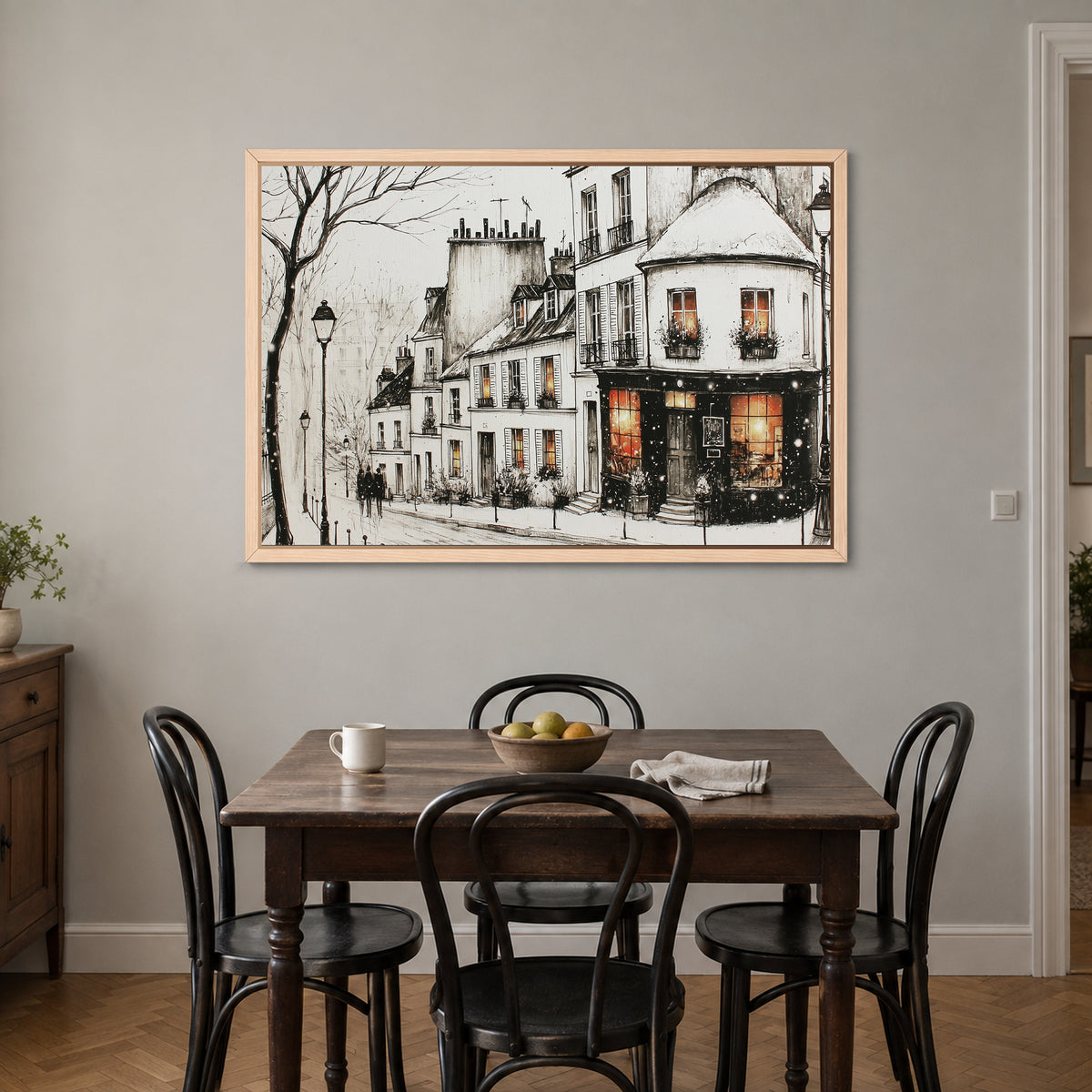 Paris Corner Shop Snow framed canvas in a natural wood floating frame above a small wooden dining table with black bentwood chairs