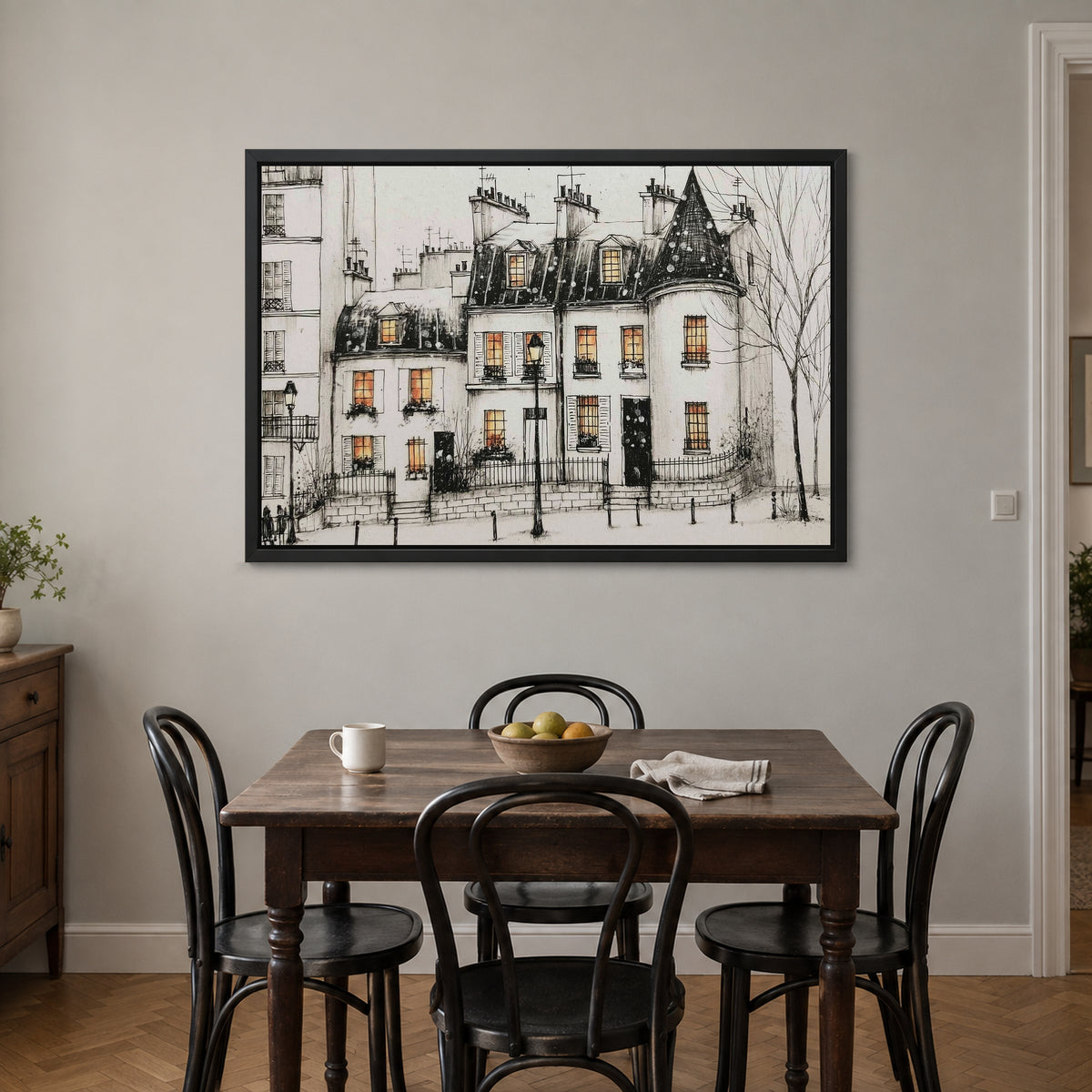 Paris Turret Rooftops Snow framed canvas in a black floating frame above a small wooden dining table with black bentwood chairs