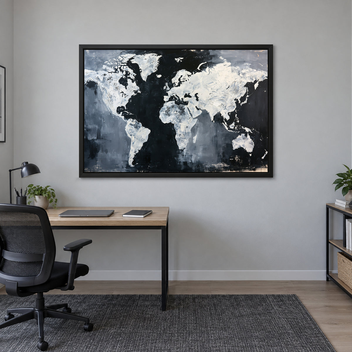 World Map Black and White framed canvas in a black floating frame above a light wood desk with a black office chair in a home office