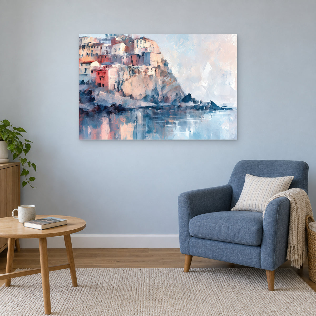 Cinque Terre Cliff Houses Coastal canvas wall art above a blue armchair and round wooden side table in a reading corner